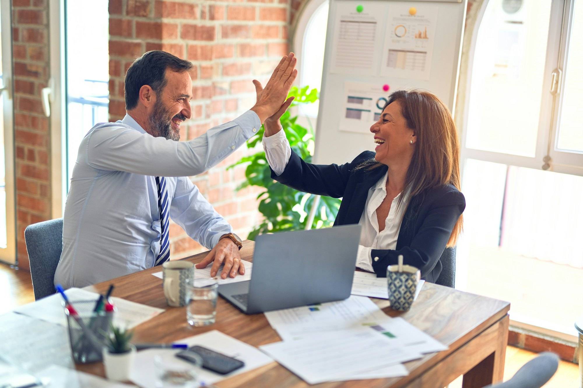 Two partners celebrating in a meeting room